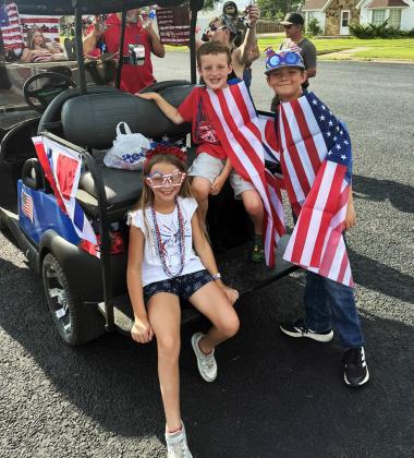 PATRIOTIC PARADE Lilly Belongia, Braxton Reiter and CJ Belongia showed their patriotic spirit with American flags, accessories and festive attire as they joined the parade during Post’s 2026 Fourth of July Celebration. | LACEY REITER