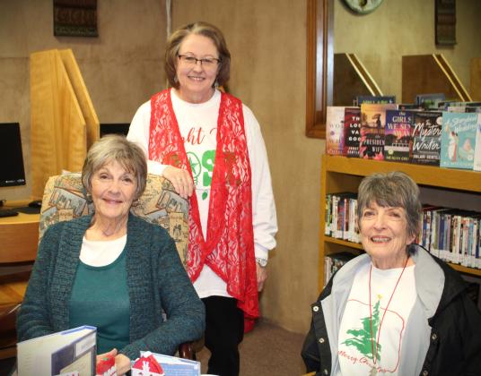 OPEN HOUSE Post Public Library hosted a Christmas Open House last Thurs. Dec. 14. Librarian Pam Humble served hot cider and cookies to avid readers Beth Cook and Carolyn Black. The library will be closed today through Dec. 26. Pam reminds everyone to come in next week, Dec. 27 through Dec. 29 and check out the new books selections. | JULIA CHILDS PHOTO