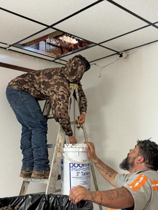 HONEY REMOVAL Sierra Hodge and Dale Span remove an estimated 200 pounds of honey from the Post Community Center. | COURTESY PHOTO