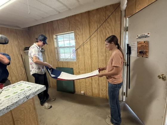 Destry Fox and Leightyn Reiter folding the flags after the shoot.
