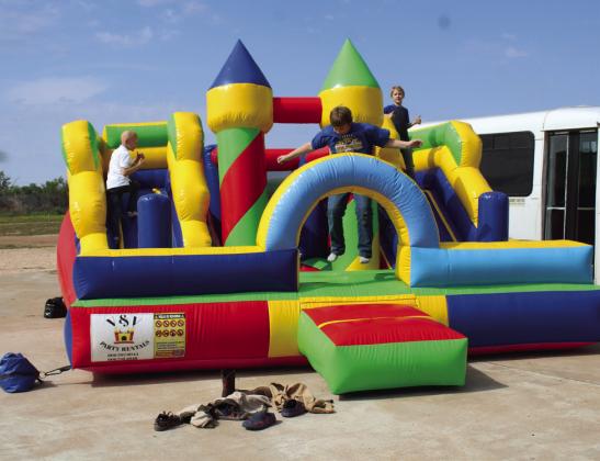 CHILDREN FROM MTC FAMILY PLAY ON BOUNCE HOUSE.