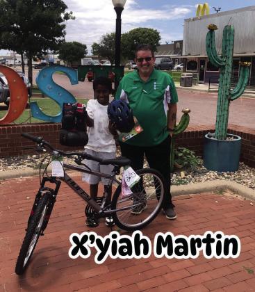 DRAWING WINNER Chris Atkinson presents X’yiah Martin, a drawing winner from July 4, with a 24” boys’ bike, along with knee and elbow pads, and helmet which was donated by the Post Community Recovery Center. | DAWN GRAVES PHOTO