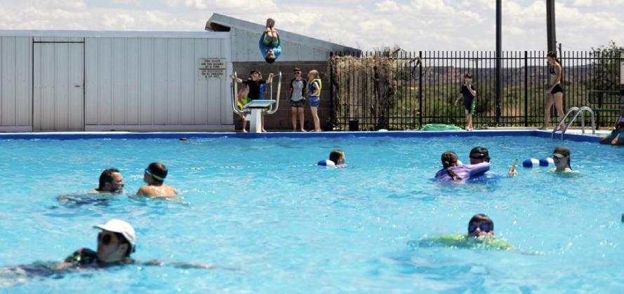 MAKING A SPLASH A Scout jumps from the diving board while fellow campers enjoy the water at the Post swimming pool during a recent dinosaur-themed Cub Scout day camp hosted by Scouting America. | COURTESY PHOTO