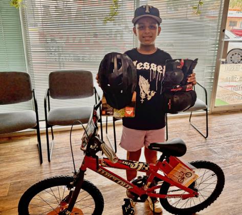 PARADE PRIZE Jonah Hernandez received his new bicycle after being selected as the winner of the boys’ drawing sponsored by Post Community Recovery Center during the Fourth of July Bicycle Parade. | COURTESY PHOTO