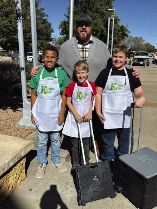 KITCHEN KINGS The junior culinary artists pose for a picture outside before heading in to their cooking challenge at the Mallet Event Center in Levelland on Tuesday, November 5. The boys named themselves the Kitchen Kings. Behind them is their coach Paul Gibson and in front from left to right is EJ Webb, Samuel Gibson and Philemon Gibson. | XANE REITER PHOTO