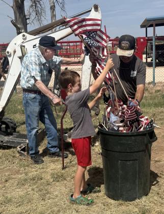 FLAG RETIREMENT Chuck Ratliff, from left, Braxton Reiter and Steve Tidwell participate in the VFW Flag Retirement Ceremony on June 28, respectfully retiring worn American flags in accordance with long-standing military tradition. | LACEY REITER