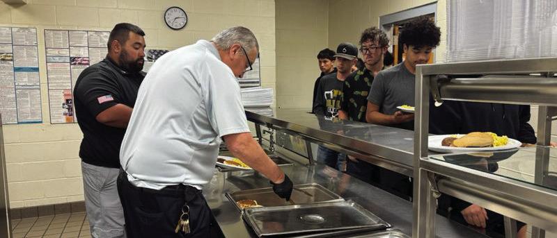 SERVING THE BOLD GOLD Sergeant Jeremiah DeLeon and Warden Martinez are pictured serving the Post JV and Varsity teams a hot breakfast on Thursday at the Post Highschool. | PHOTO PROVIDED