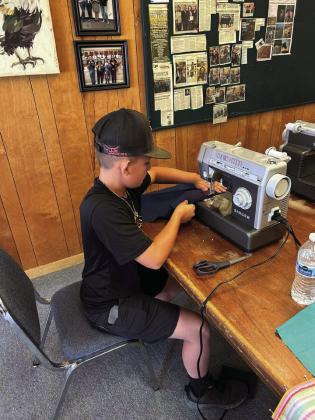 MACHINE WORK Kye Baker works hard at the sewing machine during the 4-H sewing class last Wednesday. | XANE REITER PHOTO