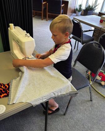 METICULOUS Connor Griffin focuses on sewing the hem of his apron during the 4-H sewing class at the Garza County Extension Office. | XANE REITER PHOTO