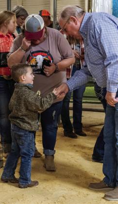 Garza County Judge Lee Norman presents Grady Dorsett with a trophy for his hard work and performance during the 2023 GCJLA show held Jan. 14 at the Syd Conner Show Barn. Each participant in the Pee Wee divisions received a trophy. Photo by Ron Francis
