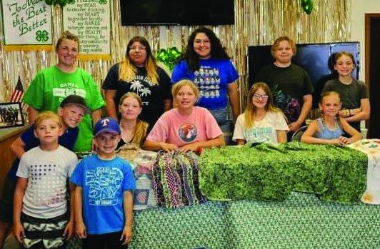 4-H members working came together to sew bibs for the nursing home at the Extension Office last week.