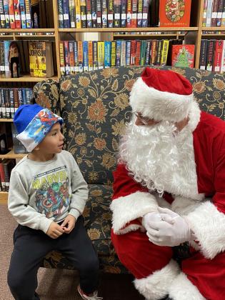 SANTA VISITS THE LIBRARY Post Public Library hosted“Cookies and Stories with Santa”last week. Children lined up to talk to the ole guy just one more time. Sharing secrets and wishes is Kyler Guerra. | PHOTO PROVIDED