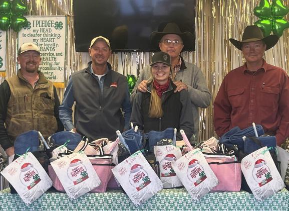 GIVING BACKTOTHE COMMUNITY 4-H partnered with the Post Stampede Rodeo Board to deliver gift baskets to t 15 individuals from the nursing home who do not have families. Rodeo board members Zane Marts, Shawn Pennell, Paul Peterson and Jon Wheeler, along with 4-H member Sylee Peterson deliver gift baskets to each of the individuals just in time the Christmas holiday. | DANYA PETERSON PHOTO