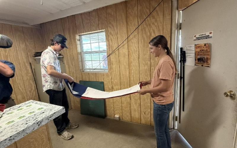 Destry Fox and Leightyn Reiter folding the flags after the shoot.