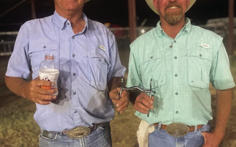 STEER STOPPING Paul Peterson presents Justin Johnson with bridal bits after winning the Steer Stopping. | COURTESY PHOTO