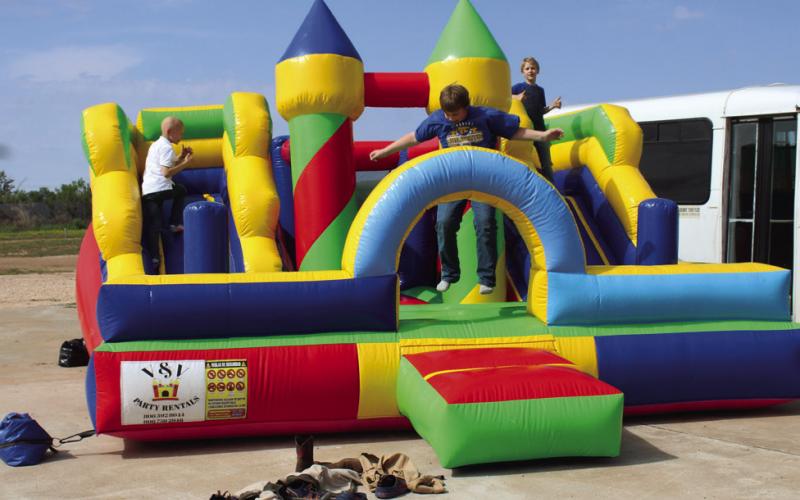 CHILDREN FROM MTC FAMILY PLAY ON BOUNCE HOUSE.