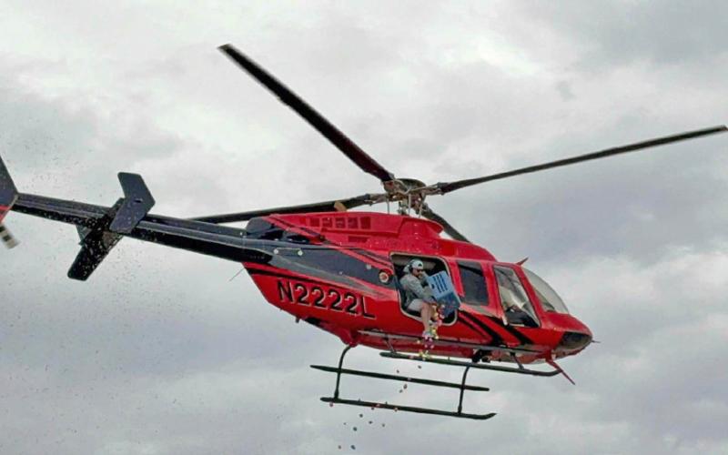EGG DROP EXCITEMENT A helicopter releases a shower of colorful eggs over Post City Park as children gather below during the community Easter egg hunt. | COURTESY PHOTO