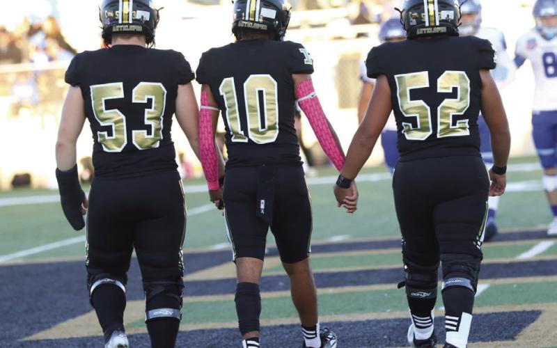 Bold Gold Antelope Team Captains, #53 Mason Wright, #10 Jamarion Reed, and #52 Alejandro Rodriguez take to the field for the coin toss.