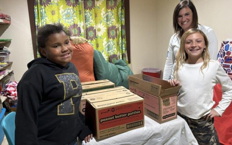 COMMUNITY GRATITUDE Dezariyah Spann and Averie Howell deliver Girl Scout cookies to Lisa Howell, secretary of the Justiceburg Volunteer Fire Department, in honor of her service. | COURTESY PHOTO