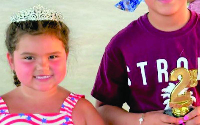 Miss Aubreigh DeLaCruz proudly wears her crown as the winner of Miss Firecracker 6-8. Annabella Graves took home the second-place trophy.