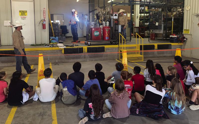 ELECTRICITY Don’t get close to the powerlines! The class looks on with amazement to see that electricity can “jump” from the lines even if they are not touching it. | ANNA GIBSON PHOTO
