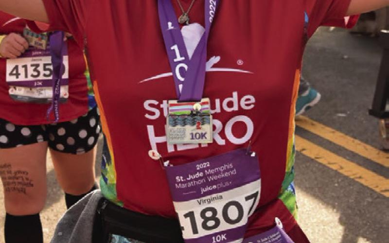 Virginia, a St. Jude Hero, is displaying the names of Nora and Stella on her arms as she prepares to run a 10K at Memphis. Photo Provided