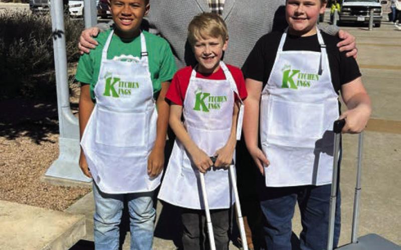 KITCHEN KINGS The junior culinary artists pose for a picture outside before heading in to their cooking challenge at the Mallet Event Center in Levelland on Tuesday, November 5. The boys named themselves the Kitchen Kings. Behind them is their coach Paul Gibson and in front from left to right is EJ Webb, Samuel Gibson and Philemon Gibson. | XANE REITER PHOTO