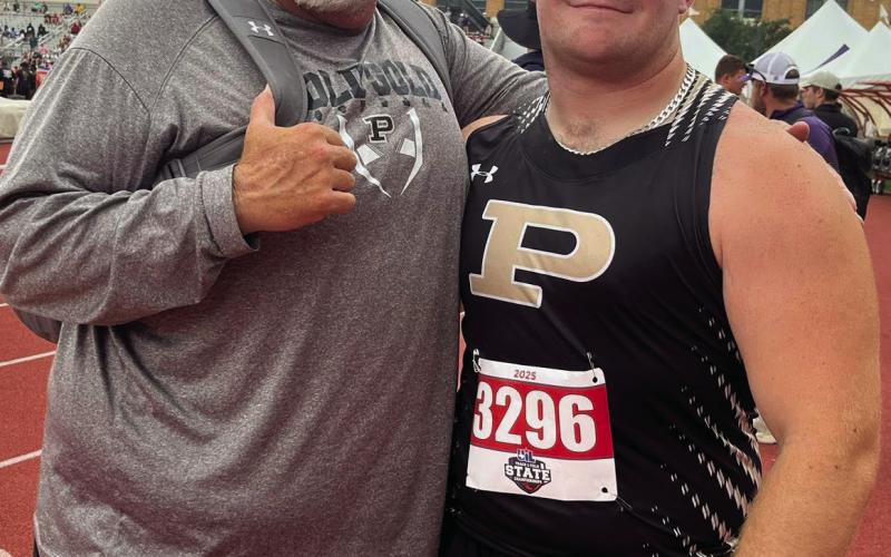SILVER MEDALIST Athletic Director and shot put coach John Wright shares a proud moment with his son, Mason Wright, after Mason earned the silver medal in shot put at the 2A StateTrack Meet in Austin and breaking a fifty-seven-year-old school record school record.