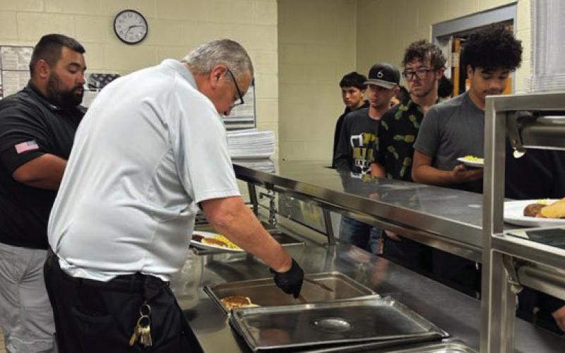 SERVING THE BOLD GOLD Sergeant Jeremiah DeLeon and Warden Martinez are pictured serving the Post JV and Varsity teams a hot breakfast on Thursday at the Post Highschool. | PHOTO PROVIDED