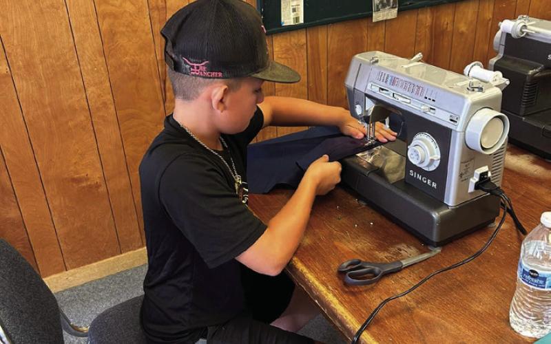 MACHINE WORK Kye Baker works hard at the sewing machine during the 4-H sewing class last Wednesday. | XANE REITER PHOTO