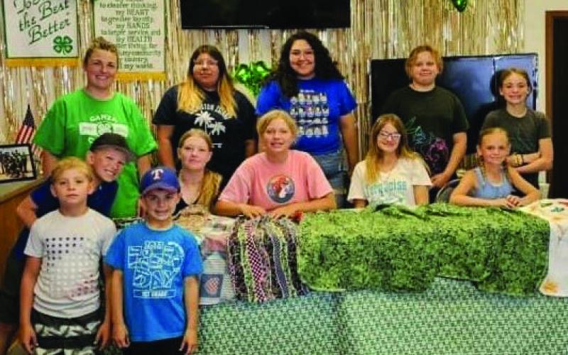 4-H members working came together to sew bibs for the nursing home at the Extension Office last week.