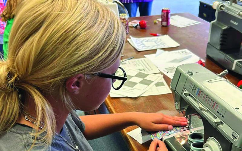 QUILT FOR RAFFLE The Garza County 4-H sewing club members Trinity Arocha, Bella Hayek, Rein Howard, and Kye Baker are working hard at sewing a Texas themed quilt to raffle for the Garza County Junior Livestock Association Homemaking Division. Tickets will go on sale November 1. | XANE REITER PHOTOS