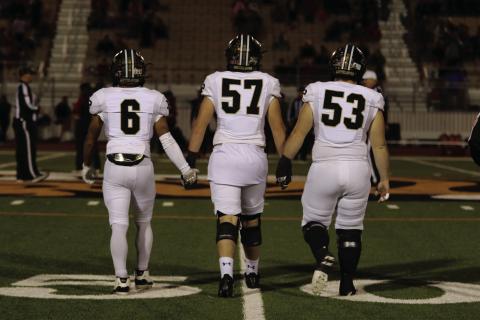 UNIFIED TEAM Ian Vergara, Cooper Osborn, and Mason Wright step to the center of the field for the coin toss before their big win that will take them to the Regional Semifinals against the Sunray Bobcats on Friday, November 29. | KHLOE SMITH PHOTO