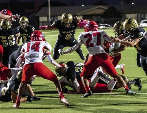 The Bold Gold fight for yardage as #6 Ian Vergara flies through the air for another “BOLD GOLD FIRST DOWN!!! Photo by Ron Francis