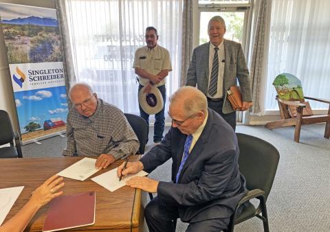 CLOSING OF SALE Curtis Hudman, president of the Public Facilities Corporation, and County Judge Lee Norman signed the sale closing paperwork of the Giles W. Dalby Correctional Facility to the State of Texas Oct. 14. | STAFF PHOTO