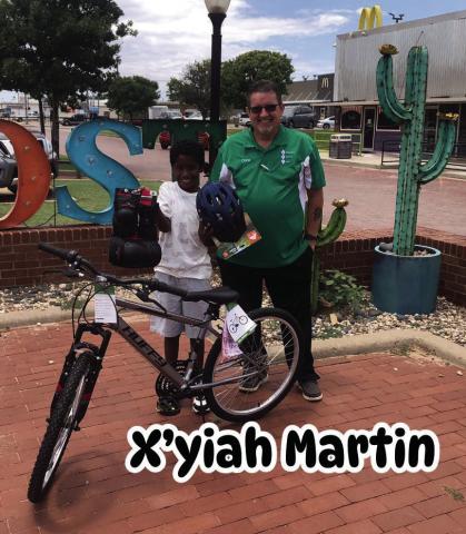 DRAWING WINNER Chris Atkinson presents X’yiah Martin, a drawing winner from July 4, with a 24” boys’ bike, along with knee and elbow pads, and helmet which was donated by the Post Community Recovery Center. | DAWN GRAVES PHOTO