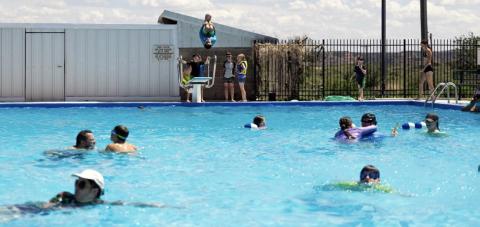 MAKING A SPLASH A Scout jumps from the diving board while fellow campers enjoy the water at the Post swimming pool during a recent dinosaur-themed Cub Scout day camp hosted by Scouting America. | COURTESY PHOTO