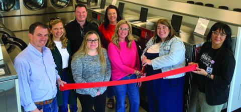 NEW LAUNDROMAT Amy Rektenwald and Hayley Mason cut the red ribbon during their grand opening on Jan. 16. Beside them on the left are Owners Jordan and Leigh Madewell, Tye Mason, Misti Day, Lupe Lazcano, and Christina Jones. | ANNA GIBSON PHOTO