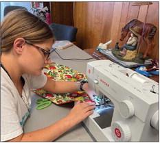 Trinity Ochoa is shown sewing up one of the bibs for the 4-H Community Service Project. Trinity a home school student is a senior Garza County 4-H group member. Photo by Julia Childs
