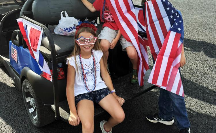 PATRIOTIC PARADE Lilly Belongia, Braxton Reiter and CJ Belongia showed their patriotic spirit with American flags, accessories and festive attire as they joined the parade during Post’s 2026 Fourth of July Celebration. | LACEY REITER