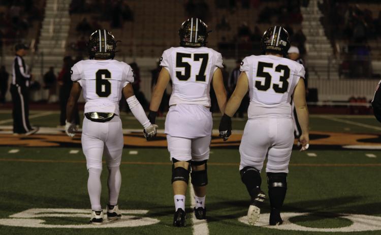 UNIFIED TEAM Ian Vergara, Cooper Osborn, and Mason Wright step to the center of the field for the coin toss before their big win that will take them to the Regional Semifinals against the Sunray Bobcats on Friday, November 29. | KHLOE SMITH PHOTO