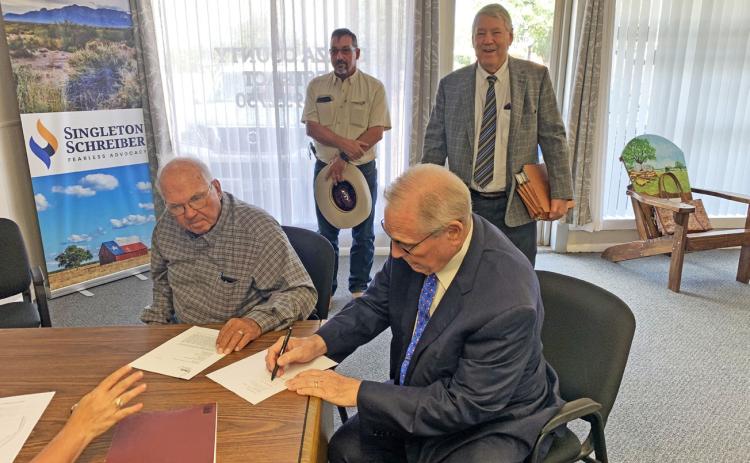 CLOSING OF SALE Curtis Hudman, president of the Public Facilities Corporation, and County Judge Lee Norman signed the sale closing paperwork of the Giles W. Dalby Correctional Facility to the State of Texas Oct. 14. | STAFF PHOTO