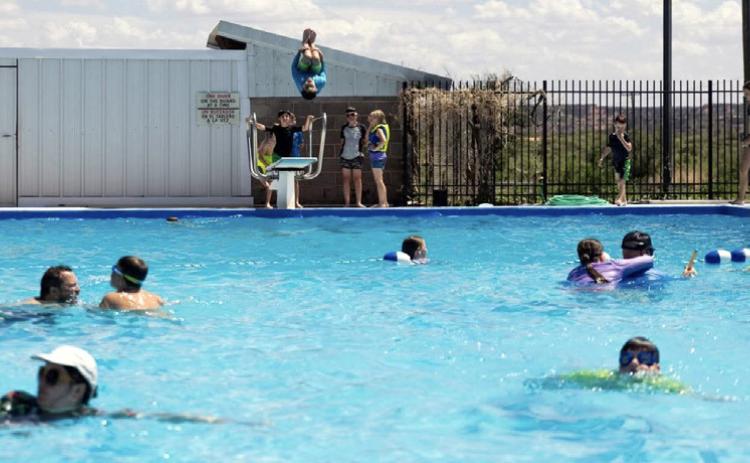 MAKING A SPLASH A Scout jumps from the diving board while fellow campers enjoy the water at the Post swimming pool during a recent dinosaur-themed Cub Scout day camp hosted by Scouting America. | COURTESY PHOTO