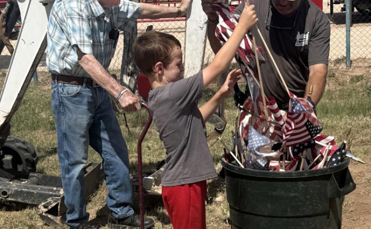 FLAG RETIREMENT Chuck Ratliff, from left, Braxton Reiter and Steve Tidwell participate in the VFW Flag Retirement Ceremony on June 28, respectfully retiring worn American flags in accordance with long-standing military tradition. | LACEY REITER
