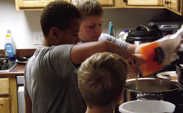 BOYS COOKING Monday, October 15, the 4-H junior food challenge team members, EJ, Philemon, and Samuel raced the clock while preparing a hearty meal. | PAUL GIBSON PHOTO
